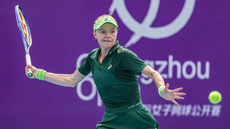 Harriet Dart, wearing all green, winds up to play a forehand